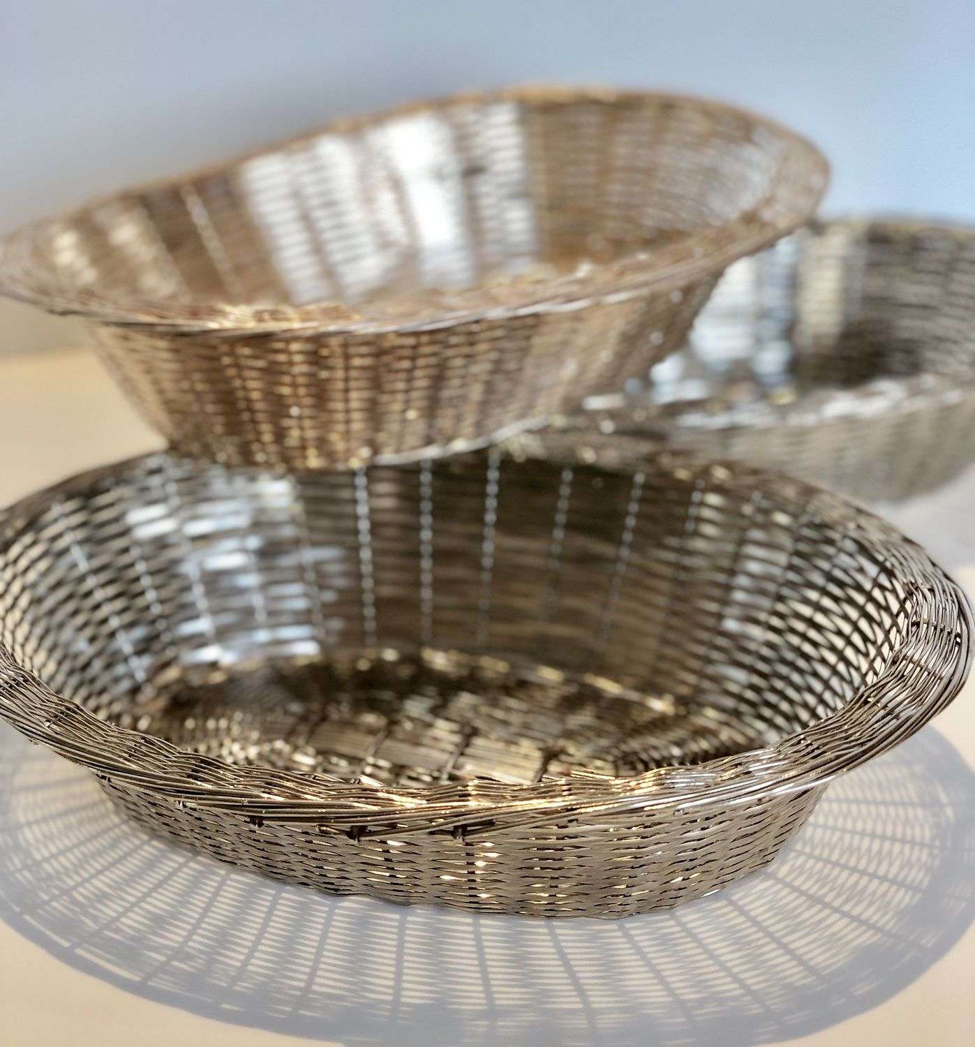 Three rustic French woven metal bread baskets
